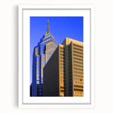 Abstract art print of Philadelphia skyline in muted blue and gray tones on a framed white mat, ideal for dining room decor.