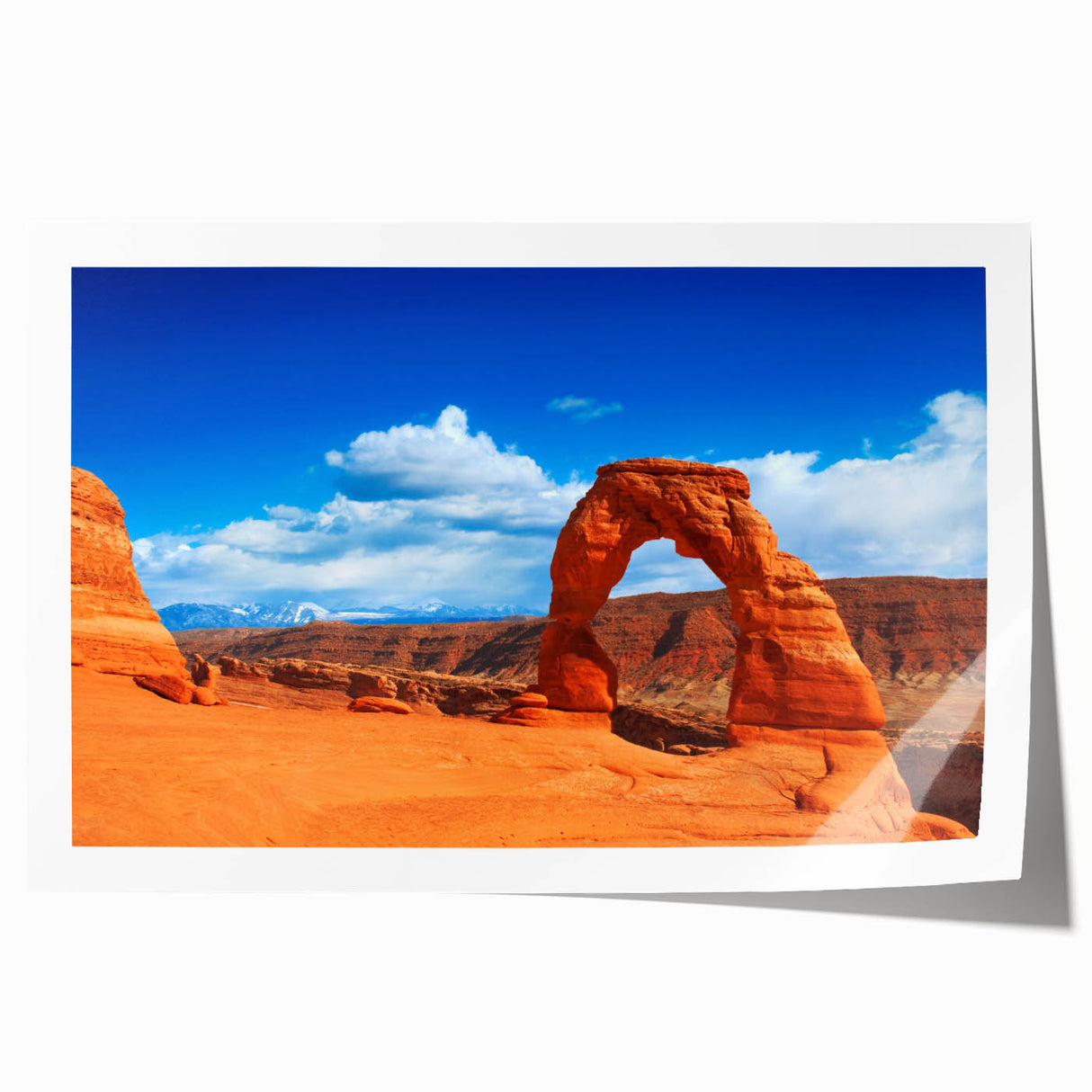 Arches National Park landscape on rolled print, featuring red rock formations under a clear blue sky.