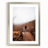 Textured abstract art print featuring warm autumnal hues on a framed silver mat, ideal for bedroom ambiance.