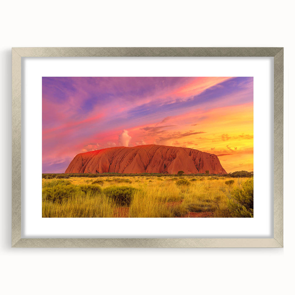 Abstract art print of Ayers Rock in muted orange and brown tones, framed in silver, suitable for dining room decor.