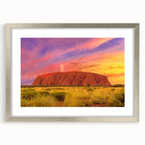 Abstract art print of Ayers Rock in muted orange and brown tones, framed in silver, suitable for dining room decor.