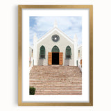 Abstract art print of Caribbean scenery in muted blue and green tones, framed in gold.