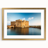 Abstract art print of a European Cyprus landscape in muted gold and blue tones, framed with a gold mat.
