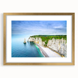 Abstract art print depicting the Normandy coastline in muted blue and green tones, framed in gold.