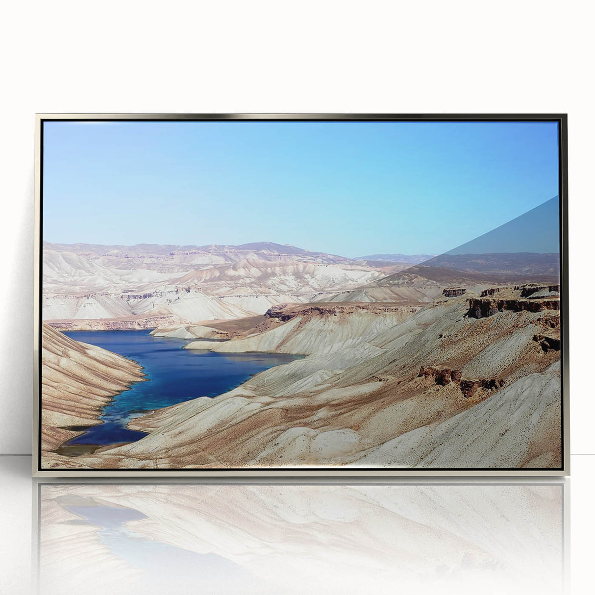 Mid-century modernist art depicting a serene Middle Eastern landscape in muted earth tones, framed in silver acrylic.
