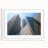 Abstract art print of Tel Aviv skyline in muted blue and gray tones on a framed white mat, ideal for dining room decor.