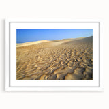 Abstract art print depicting a Middle Eastern scenery in muted earth tones on a framed white mat.