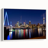 Vintage poster art of Auckland skyline, featuring colorful art on black background in a white framed canvas.