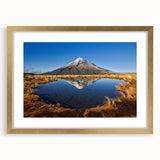 Abstract art print of Taranaki in New Zealand, featuring textured waves in muted blue and gray, framed in gold.