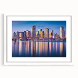 Abstract art print of Miami skyline in muted blue and pink tones on a white framed canvas, ideal for dining room decor.