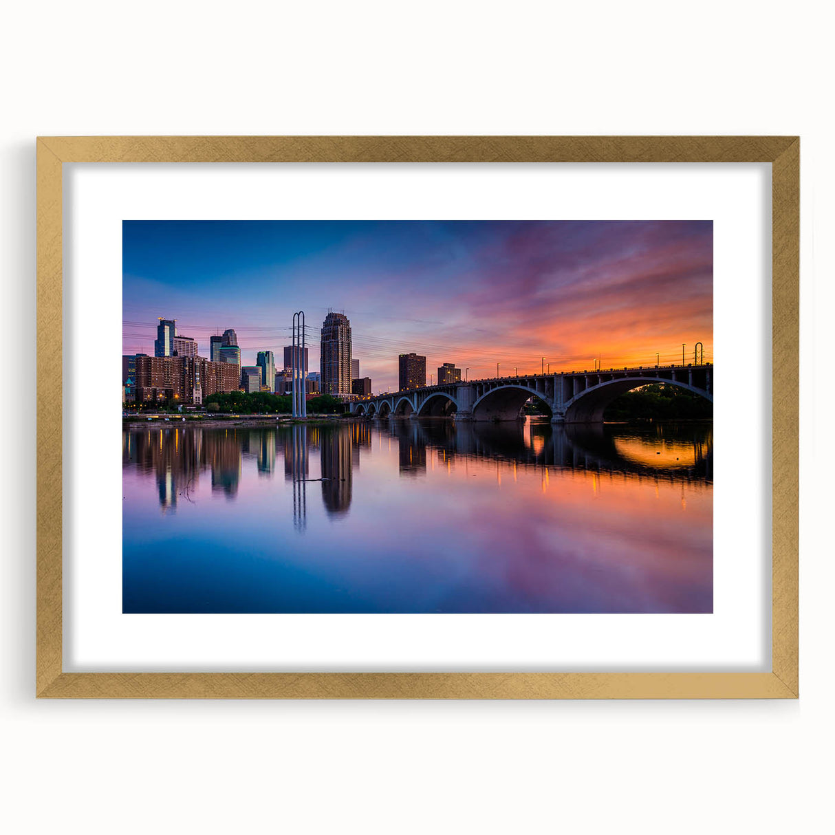 Extra large abstract art print of Minneapolis skyline in muted blue and gray, framed in gold, ideal for living room decor.