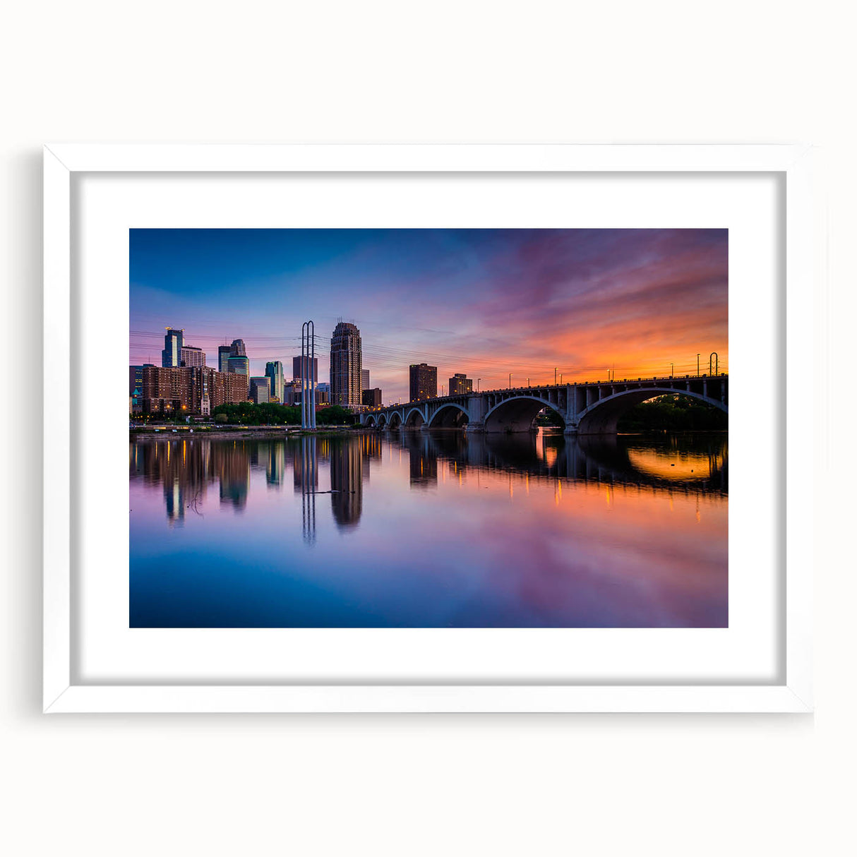 Abstract art print of Minneapolis skyline in muted blue and gray tones on a white framed mat, suitable for dining room decor.