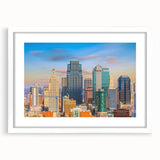 Abstract art print of Kansas City skyline in muted gray and blue tones on a white framed poster.