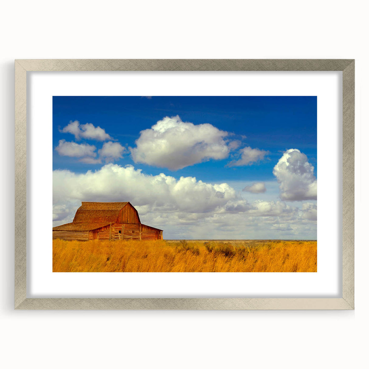 Textured art of abstract New Mexico scenery in muted earth tones, framed with a silver mat, suitable for bedroom decor.