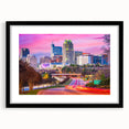 Abstract art print of a colorful, textured Raleigh skyline on a large canvas, framed in black.