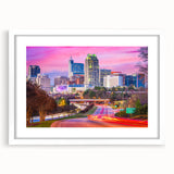 Abstract art print of Raleigh skyline in muted gray and blue tones on a framed white mat, suitable for dining room decor.