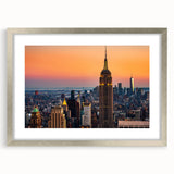 Textured art print of abstract NYC skyline in muted gray and blue tones, framed in silver, ideal for bedroom decor.