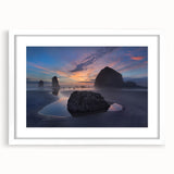 Abstract art print of Cannon Beach, Oregon, in muted gray and blue tones on a framed white mat.