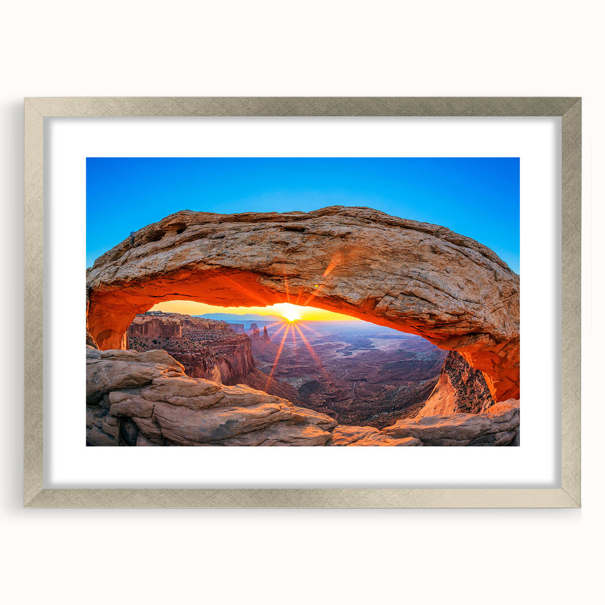 Textured art depicting Arches National Park in Utah, in earth tones on a framed silver mat, suitable for bedroom decor.
