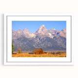 Abstract art print of the Grand Tetons in muted earth tones on a framed white mat, suitable for bedroom or dining room decor.