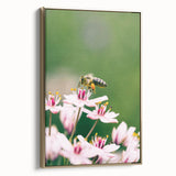 Framed canvas featuring a vintage-style landscape painting with lush spring greens and soft blue skies.