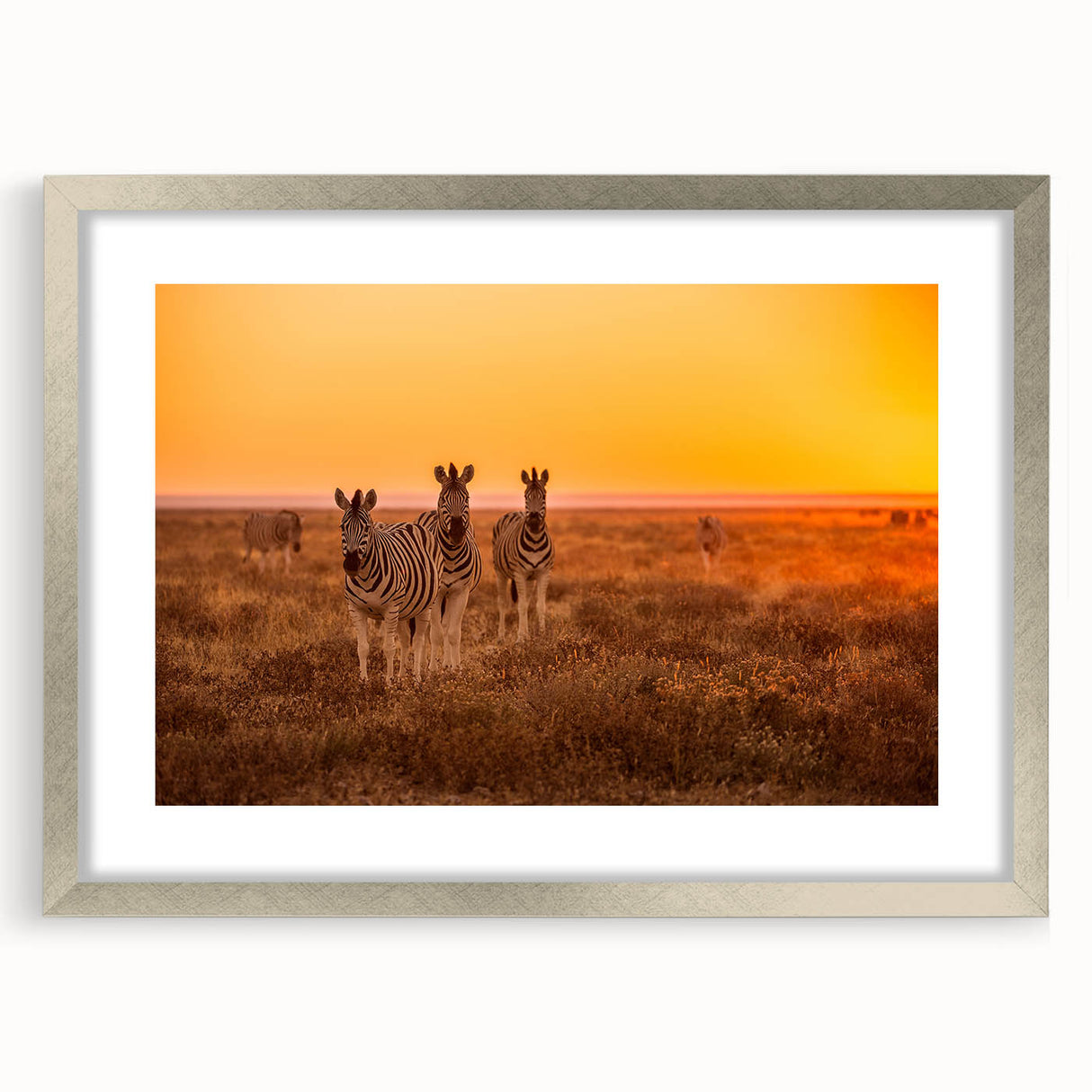 Abstract art print of an African scenery in muted earth tones on a framed silver mat, ideal for dining room decor.