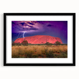 Abstract art print of Ayers Rock in vibrant orange and red hues on a black framed canvas, suitable for living room decor.