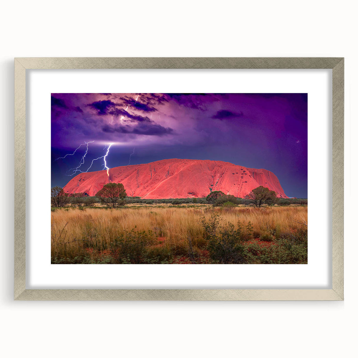 Abstract art print of Ayers Rock in muted orange and brown tones on a framed silver mat, ideal for dining room decor.