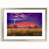 Abstract art print of Ayers Rock in muted orange and brown tones on a framed silver mat, ideal for dining room decor.