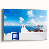 Framed canvas featuring a vintage-style landscape painting of Santorini with vibrant blue and white tones.
