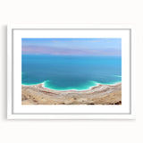 Abstract art print of the Dead Sea in muted blue and beige tones, framed with a white mat, suitable for dining room decor.