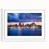 Abstract art print of Auckland skyline in muted blue and gray tones on a framed white mat.