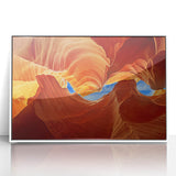 Art deco poster of Antelope Canyon in Arizona, with rich orange and red tones, framed in white acrylic.