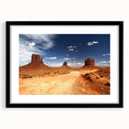 Abstract art print of Monument Valley in vibrant colors, textured on a large black-framed canvas.