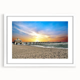 Abstract art print of a serene beach scene in muted blue and sandy tones on a framed white canvas.
