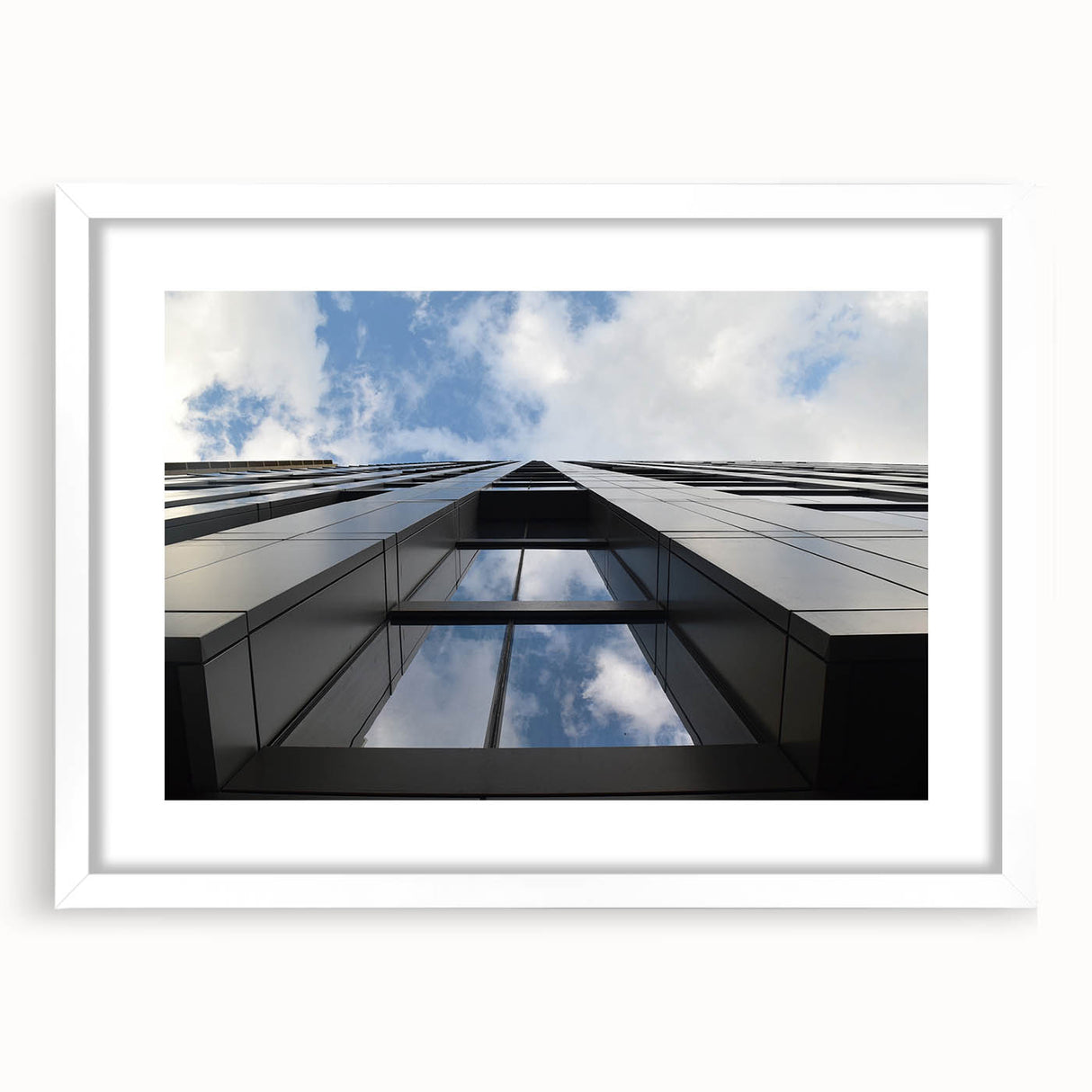 Abstract art print of Chicago skyline in muted gray and blue tones, framed in white.