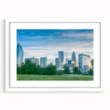 Abstract art print of Charlotte skyline in muted blue and grey tones on a framed white mat, ideal for dining room decor.