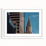 Abstract art print of the Chrysler Building in muted gray and blue tones, framed with a white mat.