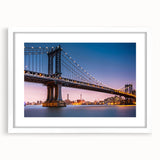 Abstract art print of the Manhattan Bridge in muted gray and blue tones, framed in white, ideal for dining room decor.