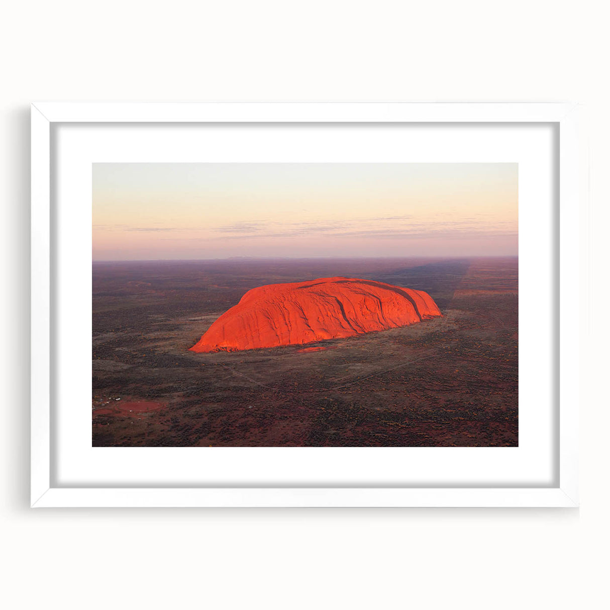 Extra large abstract art print of Ayers Rock in textured hues of orange and brown, framed in white.