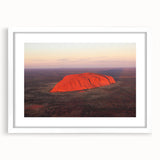 Extra large abstract art print of Ayers Rock in textured hues of orange and brown, framed in white.