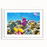 Abstract art print of the Great Barrier Reef in blue and green tones on a white framed canvas.