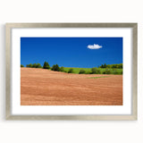 Textured abstract art print of a Canadian landscape in muted earth tones, framed in silver, ideal for bedroom wall decor.