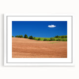 Abstract art print of a muted blue and green Canadian landscape, framed in white, ideal for dining room decor.