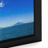 Close-up of textured black wall art featuring a colorful Central American scenery on a framed canvas.