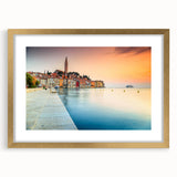 Abstract art print of a European scenery in muted gold and green tones, framed with a golden mat.