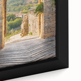 Framed canvas of a textured Tuscan landscape in black with colorful accents, ideal for living room decor.