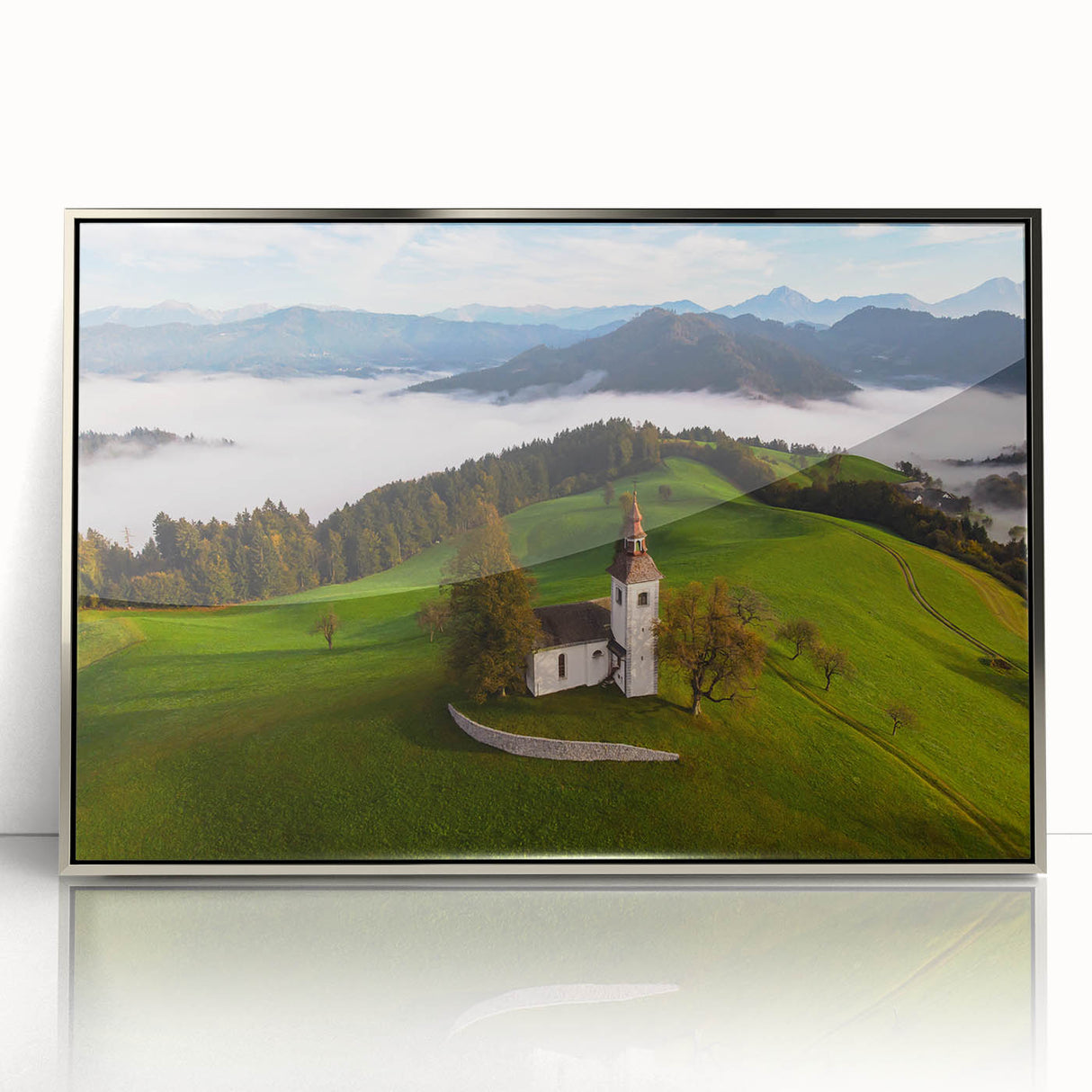 Art deco poster of a Slovenian landscape in muted greens and blues, framed in silver acrylic, ideal for nursery wall art.