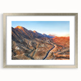 Textured abstract art print depicting a Middle Eastern scenery in muted earth tones, framed in silver.
