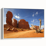Vintage poster art of Monument Valley on a framed canvas, featuring vibrant red and orange tones.